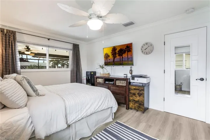 Bedroom featuring ceiling fan, ornamental molding, and light hardwood / wood-style flooring