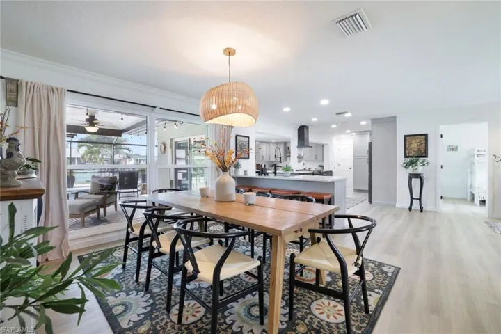 Dining area with light wood-type flooring, ceiling fan, and ornamental molding