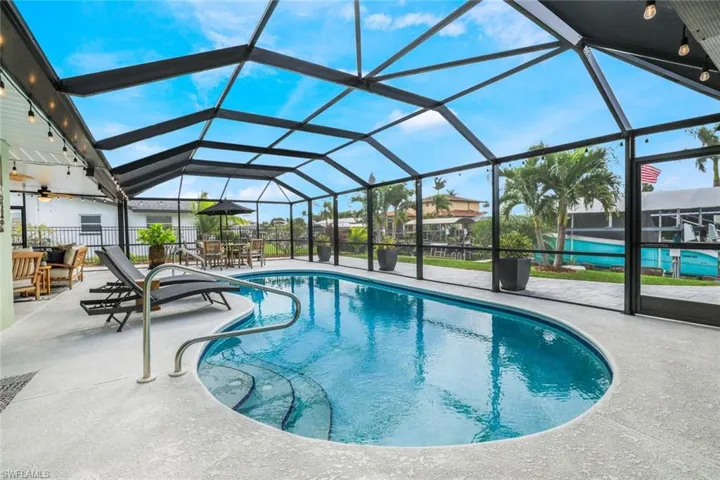 View of swimming pool featuring a patio area and glass enclosure