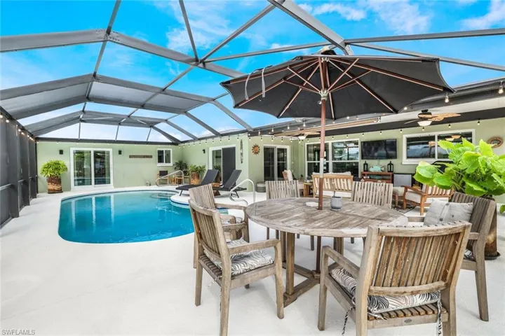 View of swimming pool featuring a patio area, outdoor lounge area, ceiling fan, and a lanai