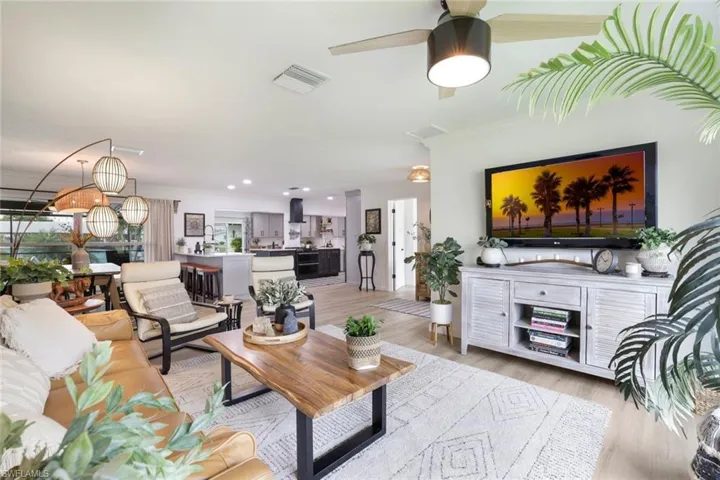 Living room featuring ornamental molding, ceiling fan, and light hardwood / wood-style floors