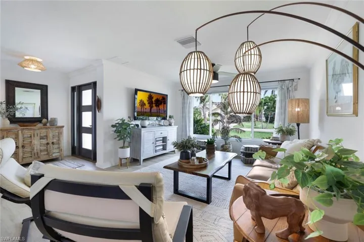 Living room with crown molding and a notable chandelier
