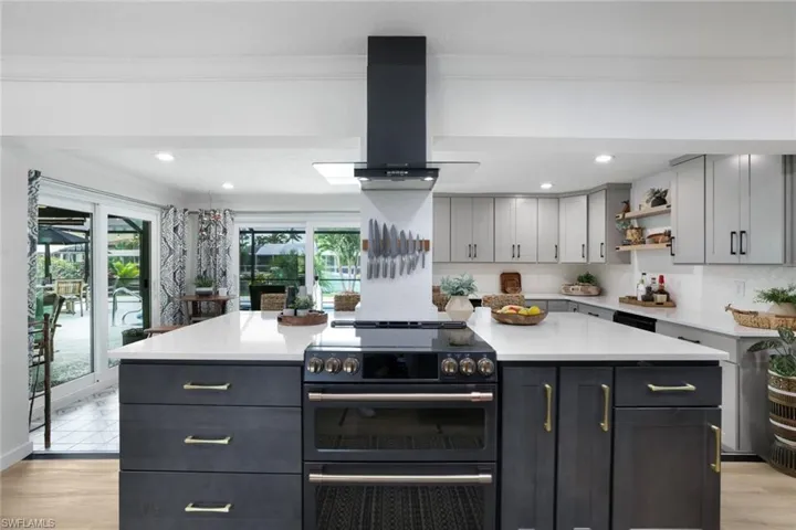Kitchen featuring a center island, gray cabinetry, stainless steel range with electric cooktop, and island exhaust hood