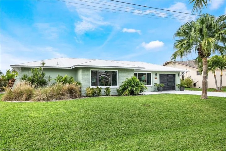 View of front of home featuring a garage and a front lawn