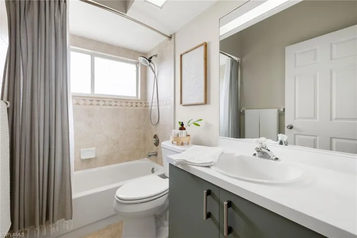 Full bathroom featuring vanity, shower / bath combination with curtain, and toilet