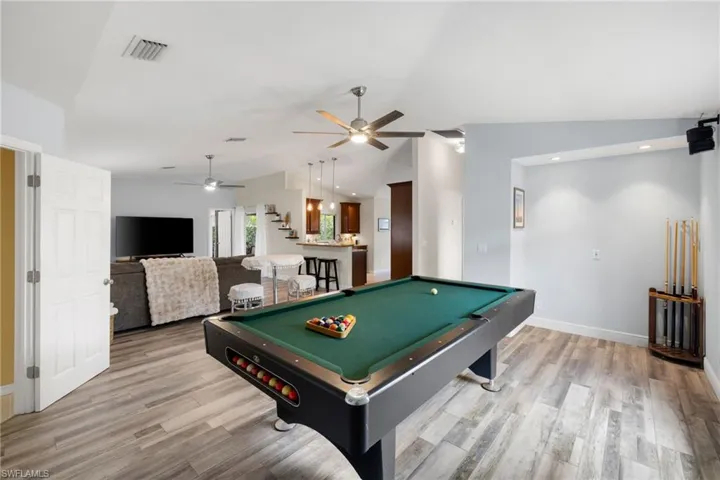 Rec room with lofted ceiling, pool table, light wood finished floors, and visible vents