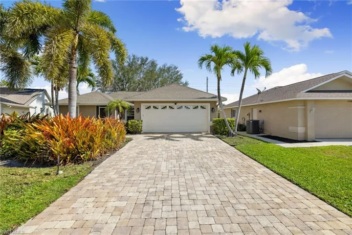 Single story home with garage, paver driveway, and stucco siding.