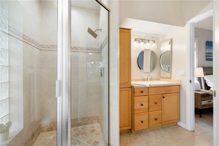 Full bathroom featuring a stall shower, ensuite bath, tile patterned flooring, and vanity