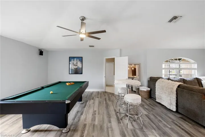 Playroom featuring pool table, wood finished floors, visible vents, baseboards, and a ceiling fan