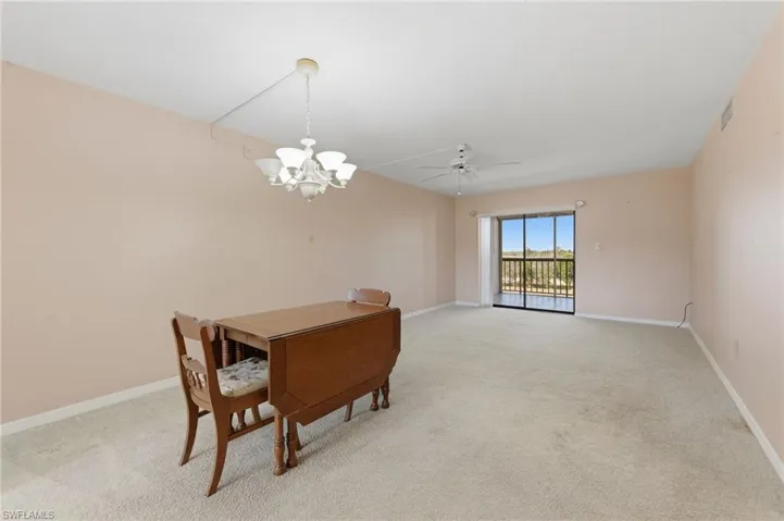 Dining area featuring light colored carpet, a chandelier, and ceiling fan