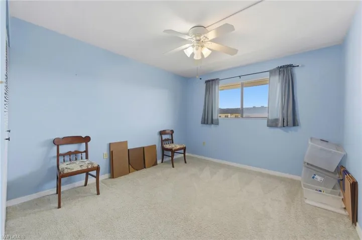 Living area with carpet and a ceiling fan