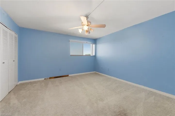 Unfurnished bedroom featuring a closet, carpet floors, and a ceiling fan