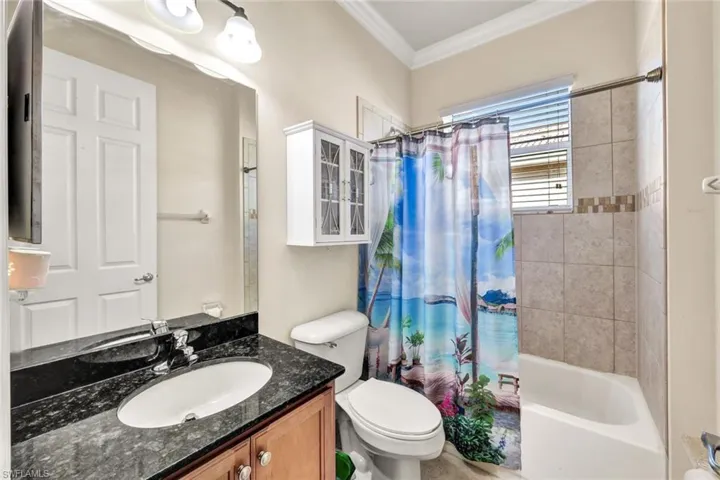 Full bathroom with vanity, toilet, ornamental molding, and shower / tub combo
