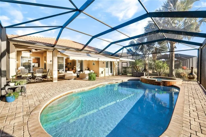 View of pool with an in ground hot tub, a patio, an outdoor hangout area, and a lanai