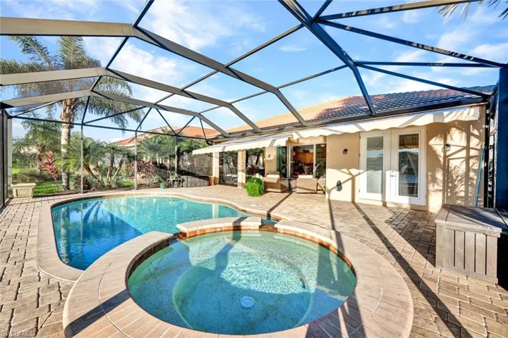 View of pool with an in ground hot tub, french doors, a lanai, and a patio area