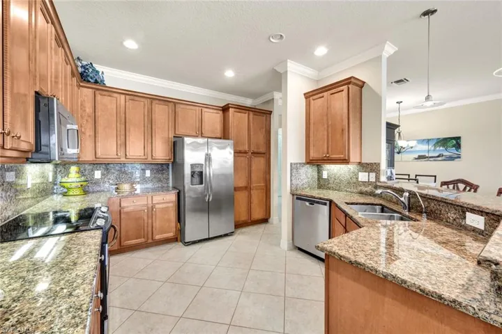 Kitchen featuring backsplash, sink, pendant lighting, and appliances with stainless steel finishes