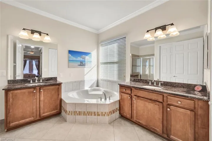 Bathroom featuring vanity, tile patterned flooring, ceiling fan, ornamental molding, and independent shower and bath