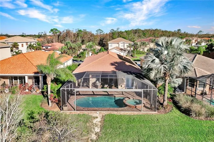 View of swimming pool with an in ground hot tub, a yard, a patio, and a lanai