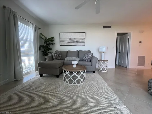 Living room with baseboards and ceiling fan
