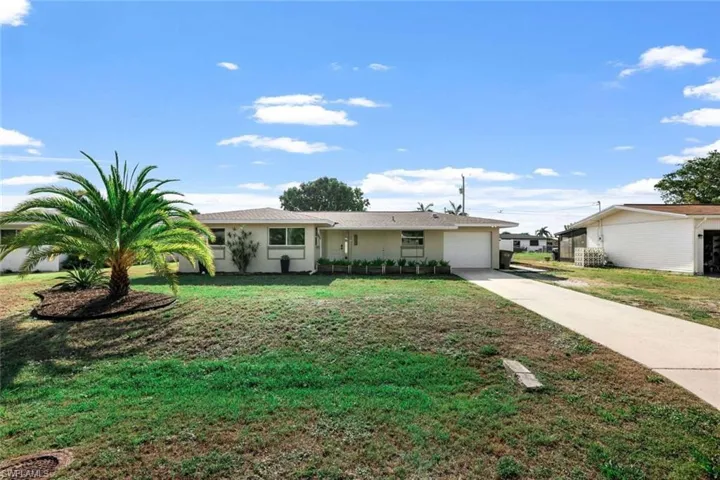 Ranch-style house with a front yard and a garage