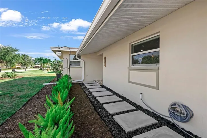 View of exterior entry with a lawn