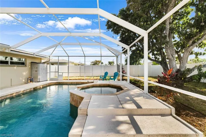 View of swimming pool featuring a lanai and an in ground hot tub