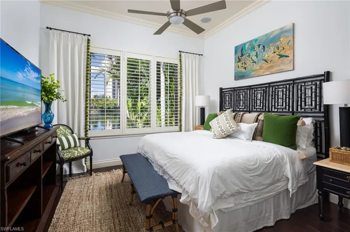 Bedroom with ornamental molding, dark wood-style floors, and ceiling fan