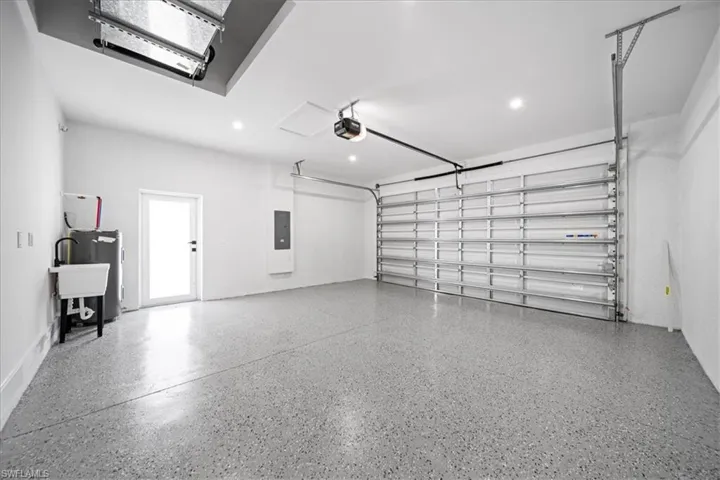 Garage featuring water heater, electric panel, and recessed lighting