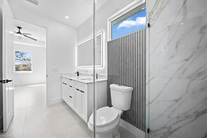 Bathroom featuring double vanity, recessed lighting, and a ceiling fan