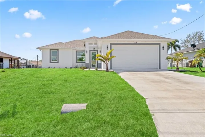 View of front facade featuring an attached garage, concrete driveway, stucco siding, a front yard, and a shingled roof