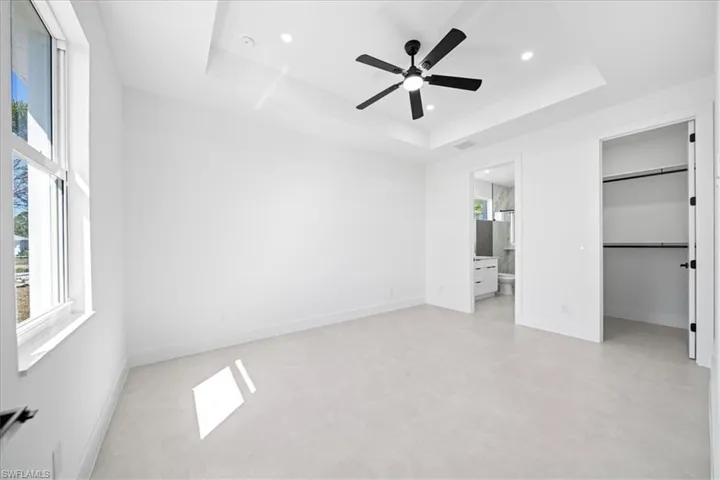 Unfurnished bedroom featuring a walk in closet, ceiling fan, and recessed lighting