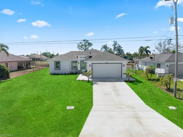View of front of house with concrete driveway, an attached garage, roof with shingles, stucco siding, and a residential view
