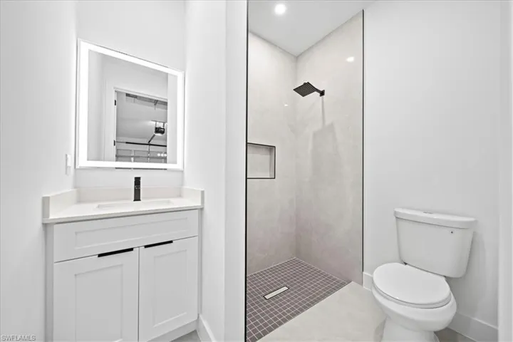 Full bath with vanity, walk in shower, recessed lighting, and tile patterned floors