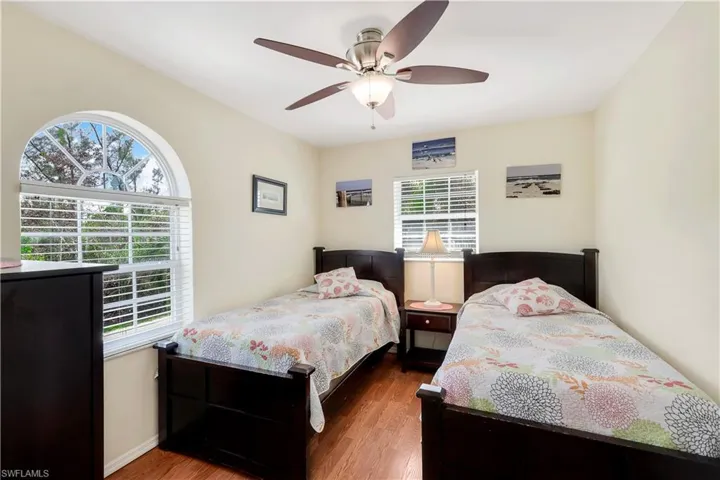 Bedroom featuring ceiling fan, dark hardwood / wood-style flooring, and multiple windows