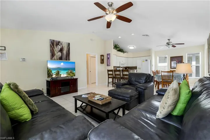 Tiled living room featuring vaulted ceiling and ceiling fan