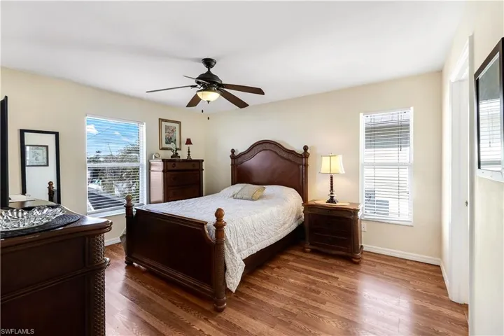 Bedroom with ceiling fan and dark hardwood / wood-style floors