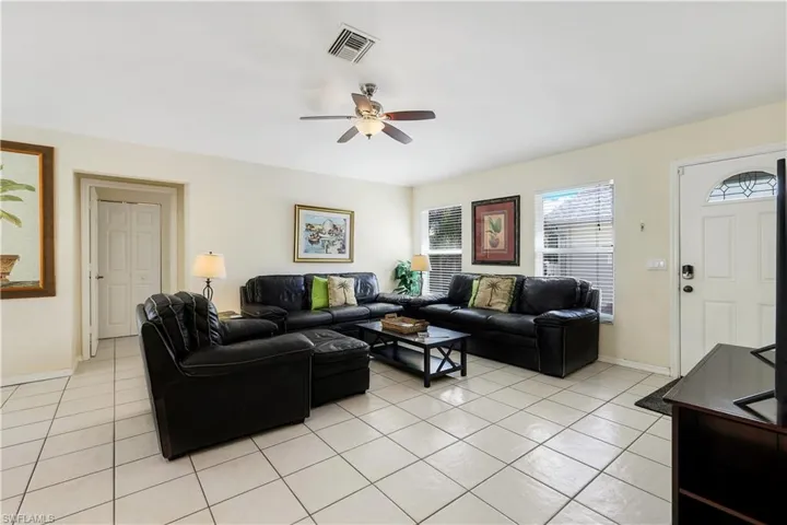 Living room with ceiling fan and light tile patterned floors