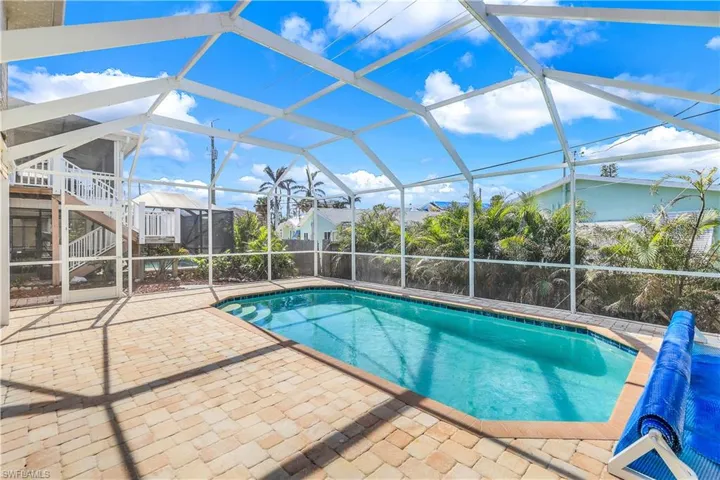 View of swimming pool featuring a patio area and a lanai