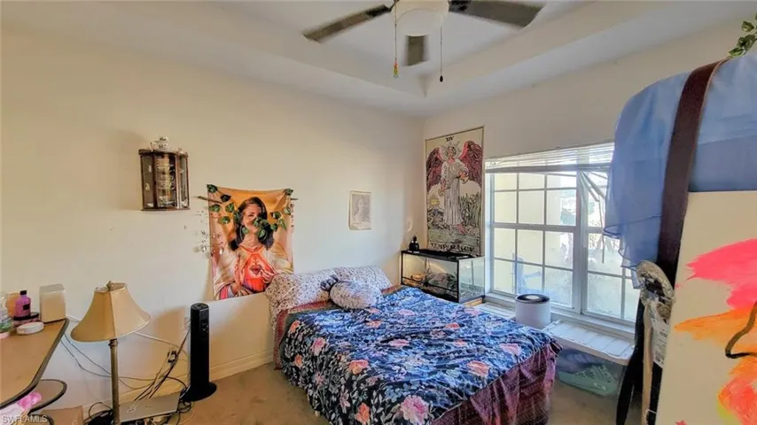 Carpeted bedroom featuring a ceiling fan