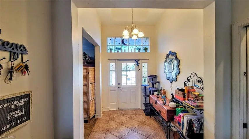 Foyer featuring a chandelier, tile patterned flooring, and a high ceiling