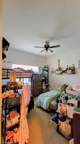 Carpeted bedroom featuring a ceiling fan