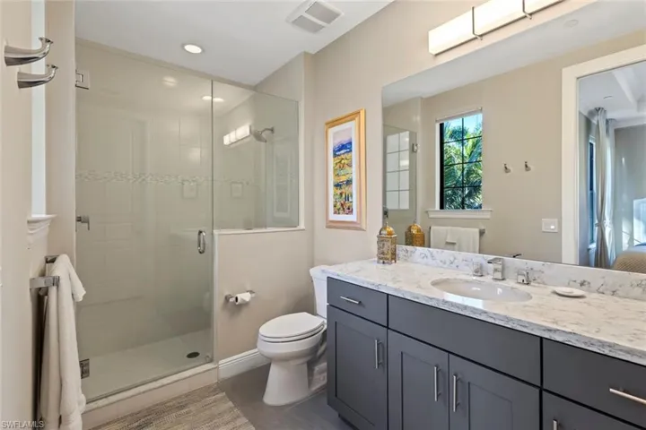 Full bath with a shower stall, vanity, and recessed lighting