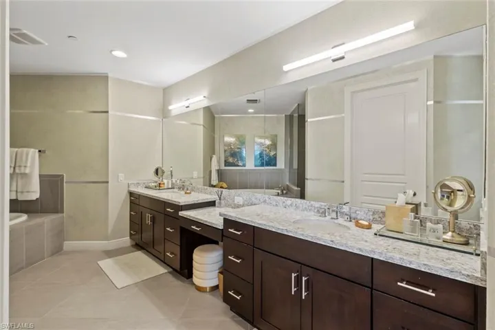 Bathroom featuring a bath, vanity, and light tile patterned flooring