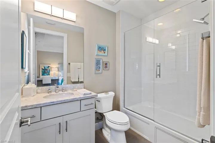 Bathroom with vanity, shower / bath combination with glass door, and ensuite bath