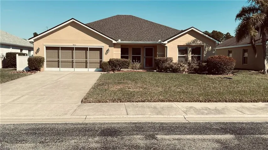 Single story home featuring a front lawn, an attached garage, stucco siding, and driveway