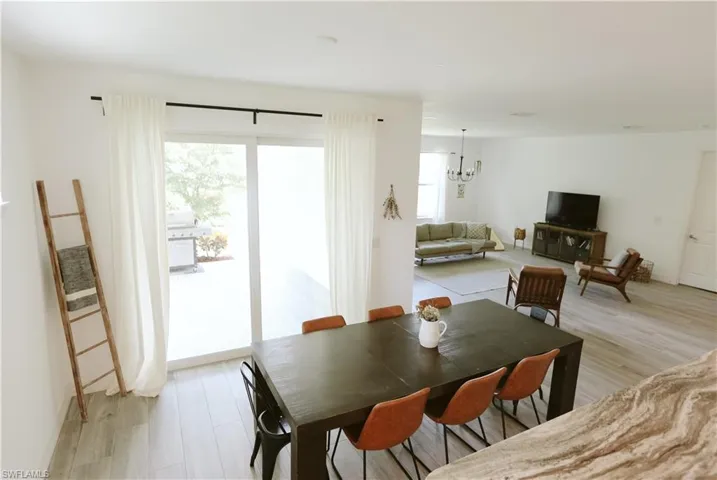 Dining area featuring healthy amount of natural light, light wood-type flooring, and a chandelier