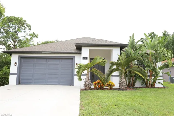 View of front of house featuring driveway, stucco siding, a front lawn, a garage, and roof with shingles