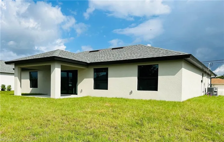 Back of property featuring a patio, a yard, and central air condition unit