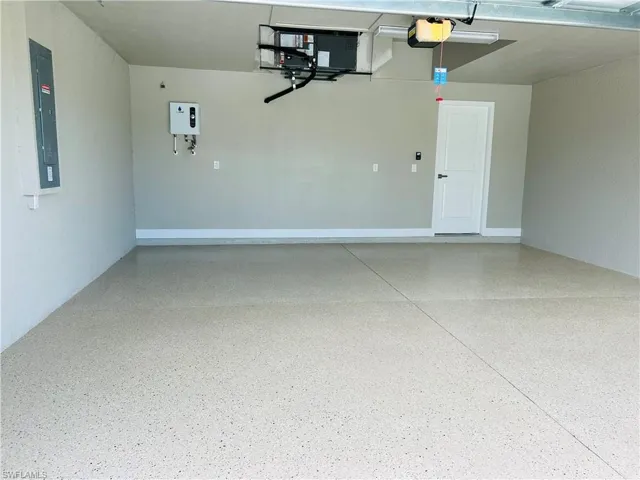 Garage with a garage door opener, tankless water heater and electric panel