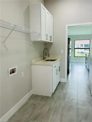 Laundry area featuring cabinets, hookup for a washing machine, and sink